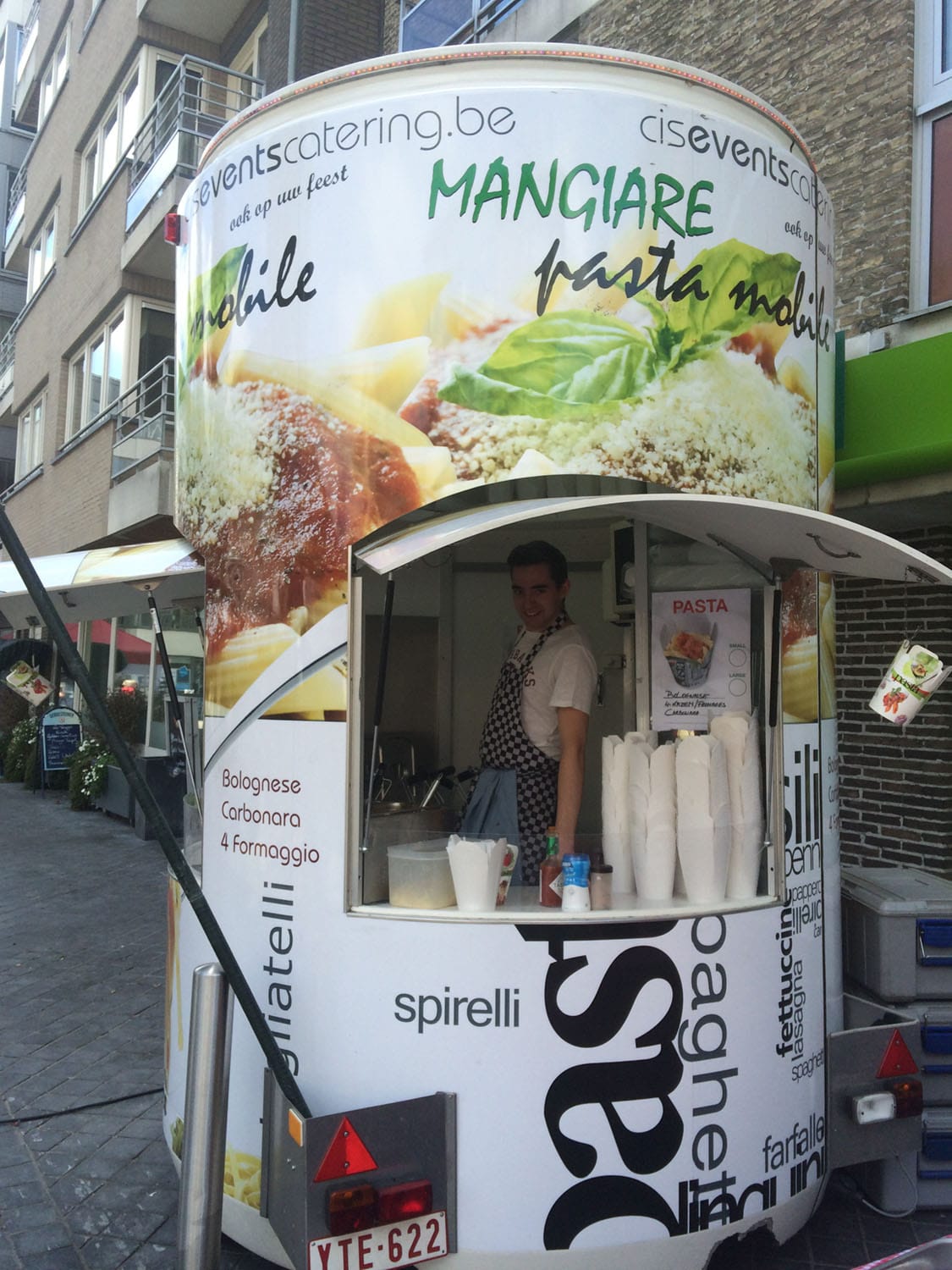 Een kok aan het werk in het loket van de pastawagen van Cis Events Catering, terwijl hij pasta serveert